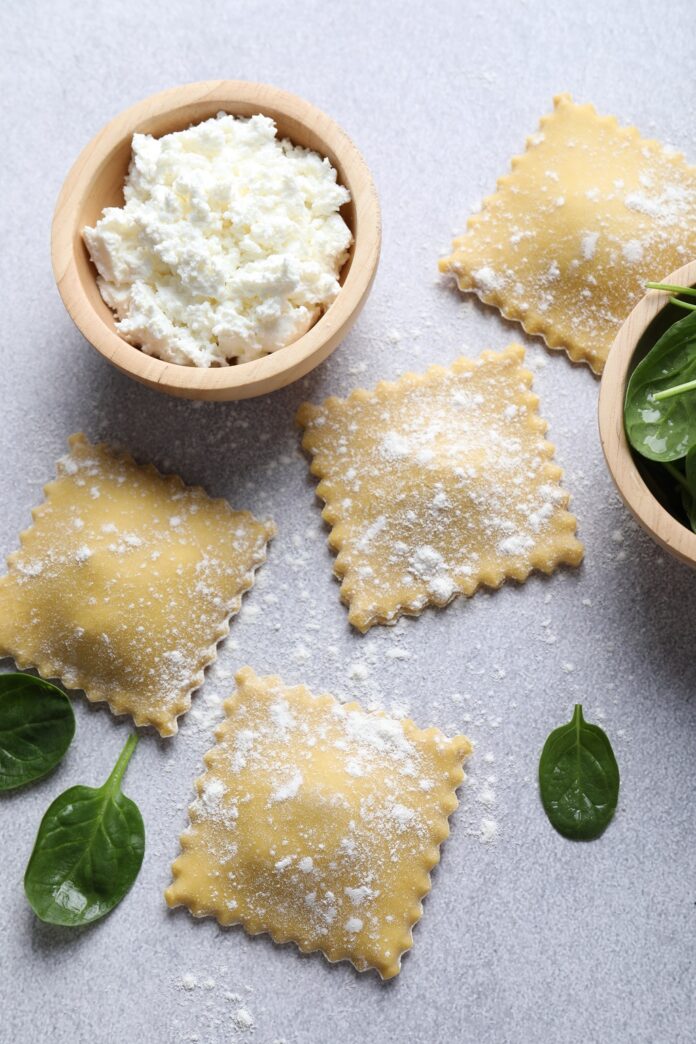 Uncooked ravioli, ricotta and spinach on light table