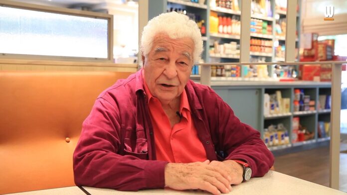 Antonio Carluccio speaking during an interview in a café setting