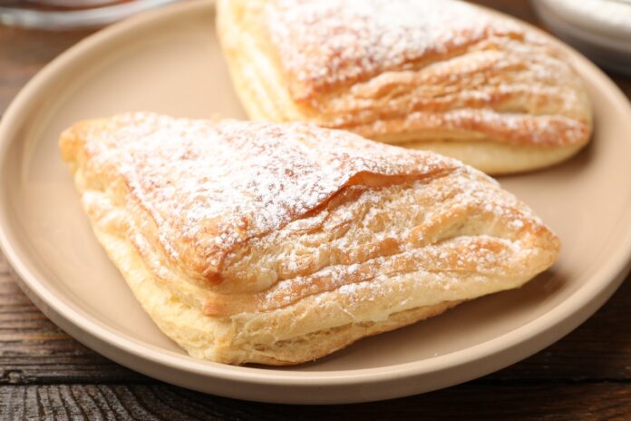 Tasty,Puff,Pastries,With,Powdered,Sugar,On,Wooden,Table,,Closeup Pastries
