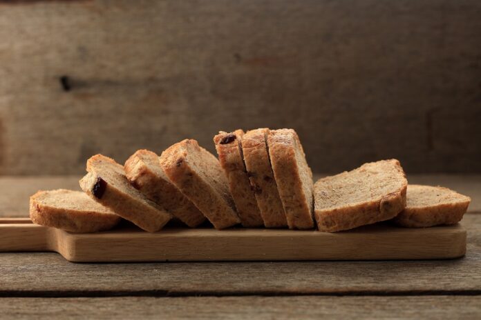 Sliced whole wheat bread arranged on a wooden board, representing a common use of whole wheat flour in baking