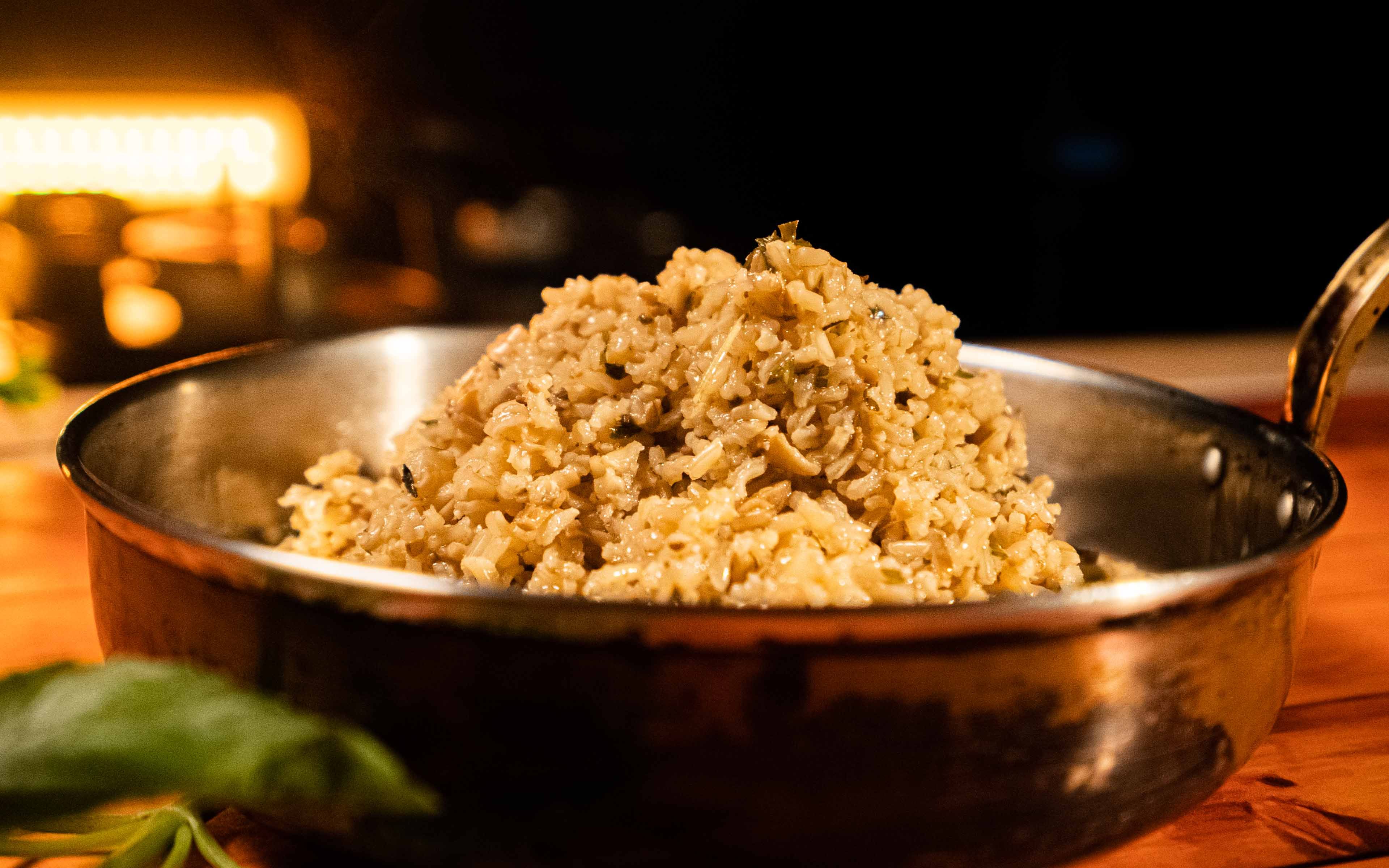 Mushroom risotto served in a copper pan, combining a finished dish with an example of copper cookware.
